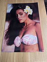 Front view of vintage photo print showing woman with flower in hair and bikini top.