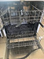 Open dishwasher interior showing racks and spray arm.