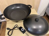 Black non-stick wok with handles, lid, and power cord with control knob