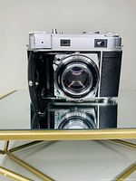 Front view of Kodak folding camera with bellows extended and lens visible