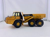 Side view showing detailed yellow and black 400D dump truck with large tires and dump bed.