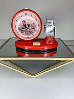 Full view of the red vintage clock combined with a manual date calendar on a reflective surface.