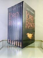 Corner view of the sealed 7-book set showing the spines of the books inside the plastic-wrapped slipcase.