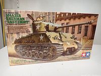 Front view of Tamiya M4A3E8 Sherman Easy Eight model kit box with detailed tank artwork and product information.