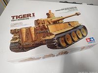 Front view of boxed Tamiya Tiger I Ausführung H plastic tank model kit showing artwork of assembled tank with crew figure and German marking.