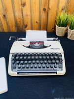Front view of Olympia SM3 typewriter, cream color, with paper loaded