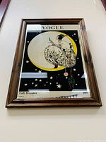 Full view of framed mirror showing Vogue cover art and wood frame.