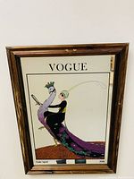 Full view of the framed Vogue magazine cover print showing the person riding a peacock illustration and text 'VOGUE' at top and bottom date details.