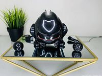 Black Volkswagen Fast GTI promotional collectible figure with three separate accessory pieces placed around it on reflective surface.