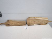 Two natural unfinished butternut serving boards side by side showing different grain patterns and live edge detail