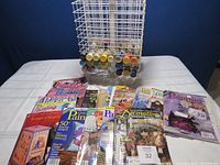 Photo of the paint storage spinner/caddy with multiple acrylic paint bottles visible, and a collection of tole painting books and magazines arranged in front.