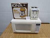 Front view showing GE microwave, Iona stand mixer box, and Hamilton Beach toaster on microwave.