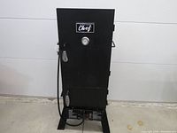 Full front view of MasterChef propane smoker showing upright cabinet, door with spring handle, gauge and control panel