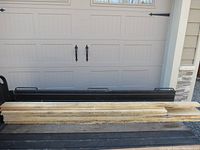 Stack of seven rough sawn birch lumber pieces laid on a truck bed with a garage door in the background.