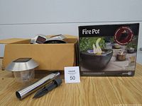 Photo shows cardboard box containing stainless steel solar lights and separate boxed ceramic Fire Pot.