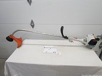 Full view of Stihl FS 38 trimmer laid on table with manual