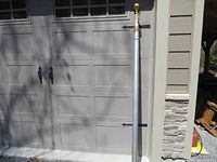 Full view of retracted pole leaning against garage door