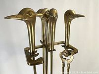 Close-up of the brass duck head design on the fireplace tool handles