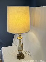 Lamp lit with fabric shade glowing, showing height, shape, and overall design.