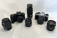 View of all cameras and lenses in the lot, showing two camera bodies with multiple lenses in front.