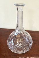 Full view of the vintage round-bottomed crystal decanter showing the etched decorative cut patterns on the rounded body.