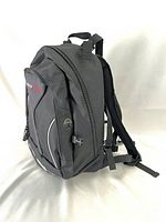 Side angle view of black Obusforme day pack showing overall structure, shoulder strap, and side pocket mesh.
