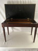 Front view of the bench with hinged lid open showing wood frame and interior storage compartment.