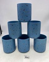 Front view of six blue ceramic planters stacked pyramid style, showing multicolored confetti speckles on each.