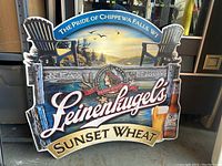 Front and full view of the Leinenkugel's Sunset Wheat beer metal sign showing Adirondack chairs, lake scene, and bottle.