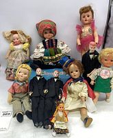 Full group of vintage dolls including 3 male grooms, various costumes, and the Success box in background