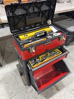 Image of Husky tool chest showing open top lid with tools inside and two opened drawers revealing sockets, ratchets, and empty drawer.