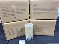 Four boxes of LED flameless candles, each box with 6 pieces, labeled with product details about indoor/outdoor use, timer, battery requirements.