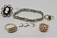 Lot of sterling silver jewelry including a CZ tennis bracelet and multiple rings including a cameo and cluster opal ring