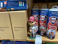 Four cardboard boxes labeled 'Bobblehead - Philadelphia Phillies' and four cans of Phillies Cooling Towel on a shelf.