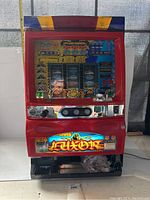 Front view of red and black Sammy Luxor slot machine showing illuminated Luxor artwork and chrome control panel with buttons and lever.