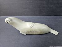 Side view of the soapstone seal sculpture showing shape, facial features, and surface details.