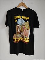 Front of black Lady Gaga T-shirt with colorful Telephone graphic and text