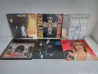Overview of six vintage vinyl records including Rush, Guns N' Roses, The Replacements, George Thorogood, and a record titled Actor.