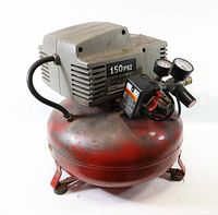 Front angled view showing red pancake tank and grey motor housing with 150 PSI label and gauges.