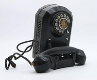 Front and side view of the black Bakelite wall rotary telephone with handset and rotary dial visible.