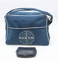 Front view of blue Pan Am airline bag with white piping and Pan Am logo, alongside small black toiletries kit bag.