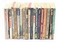 15 vintage James Bond paperback books standing upright, showing spines with titles and publisher details.