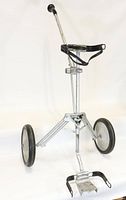 Vintage AJAY Playmate golf bag caddy standing open showing tripod metal frame, two large wheels, handle and securing strap.