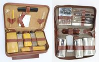 Chestnut leather travel set opened showing clear and mustard celluloid grooming bottles, comb, brush, and other accessories inside zippered tan interior.