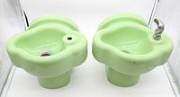 Pair of vintage light green porcelain water fountains, one with spout and one with drain and tap visible from front and top