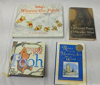 Top-down view of all four vintage Winnie the Pooh books laid out, showing front covers and some wear signs.