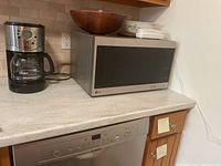 Oster coffee maker and LG microwave on kitchen countertop.