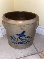 Full front view of the stoneware crock pot with blue floral decoration visible.