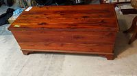 Front and side view of the rectangular cedarwood blanket box showing the reddish-brown finish and bracket feet.