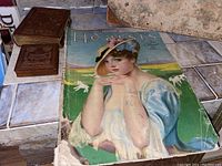 Full view of Hearst's magazine showing cover with woman in hat and dress, alongside brown embossed leather photo albums.